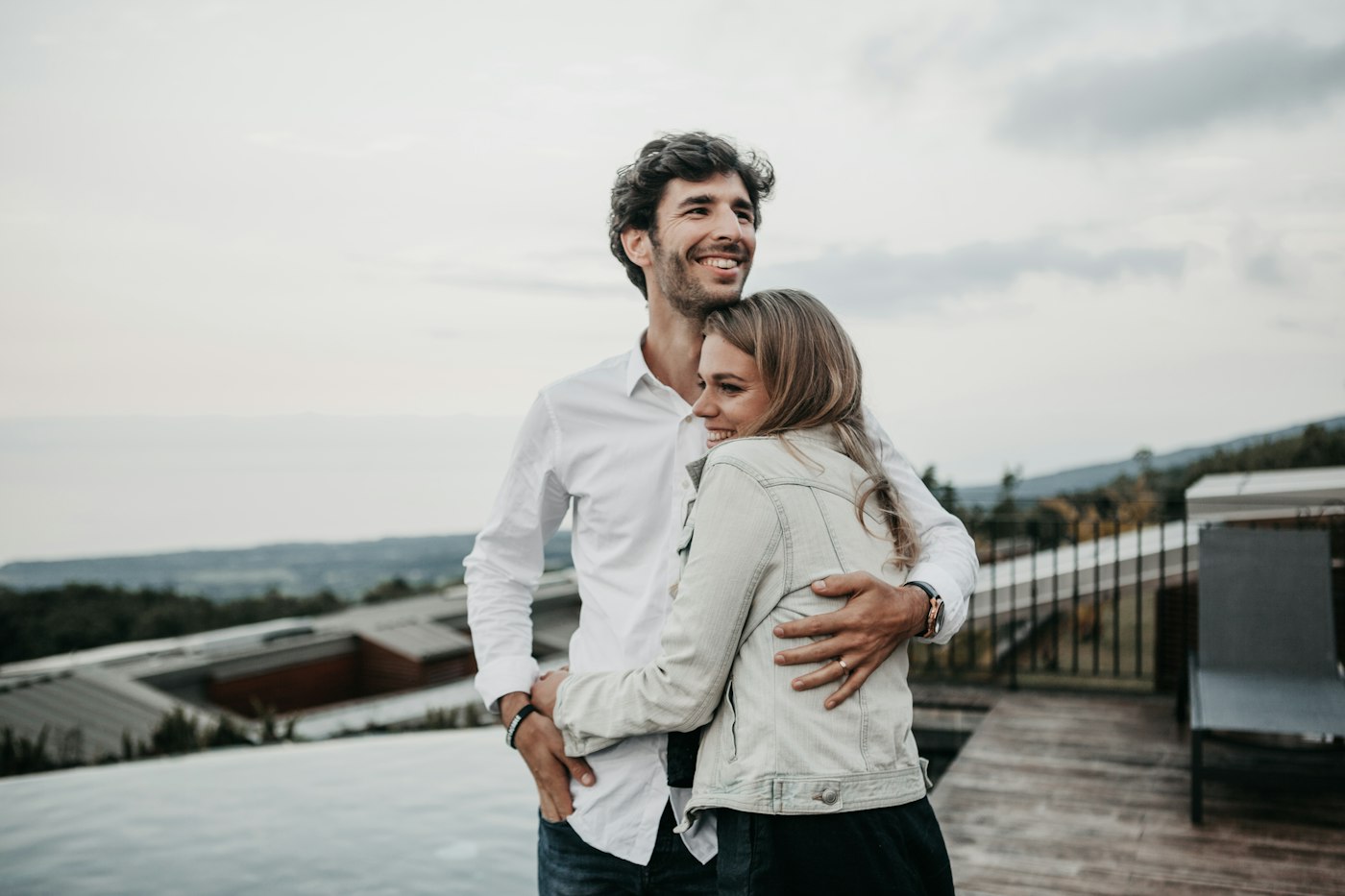 Um casal se abraça e sorri ao ar livre
